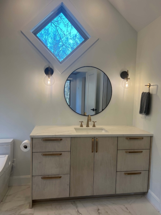 Bathroom Remodel by Lutke Construction including new tile, recessed lighting, custom lighting, new vanity, mirror and more.