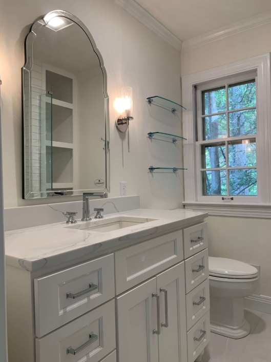 Bathroom remodel project completed by Lutke Construction included new vanity, mirror, shelving, flooring and more.